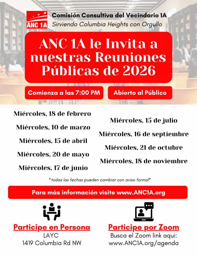 Urban plaza with a round fountain, surrounded by shops and light traffic